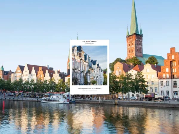 Colorful historic buildings line a calm Lübeck canal with a boat; a tall church spire rises in the background, while a white ad overlay sits center.