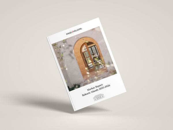 Open magazine with graphs and a photo by the sea; adjacent is a closed report titled "Market Report Balearic Islands 2025-2026."