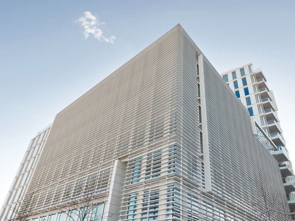 Close-up of a modern office building with a distinctive louvered facade in Baden bei Wien, symbolizing innovative cooperations by Engel & Völkers.
