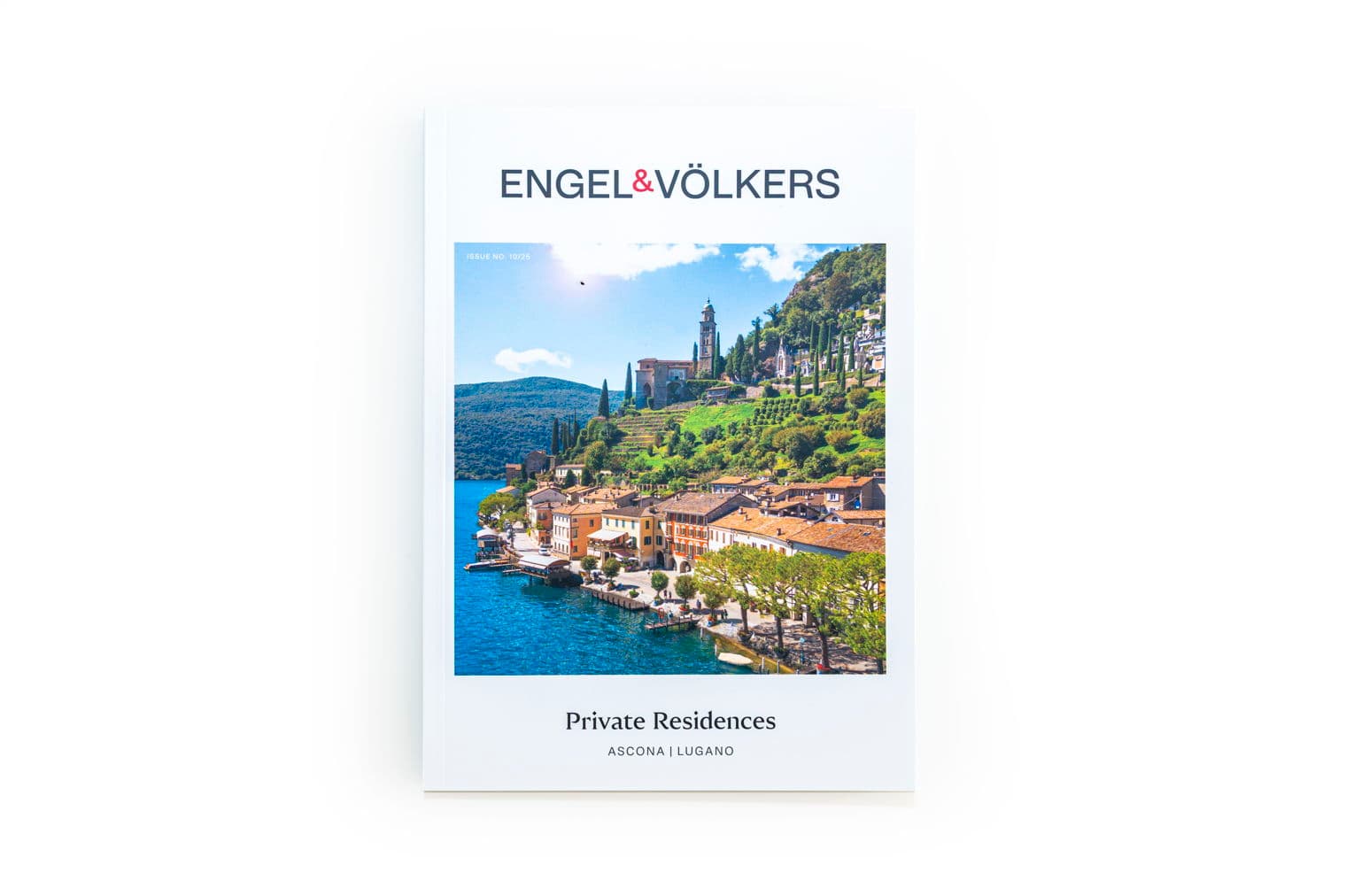 Engel & Völkers magazine cover featuring a lakeside town with colorful buildings and a church on a hill.