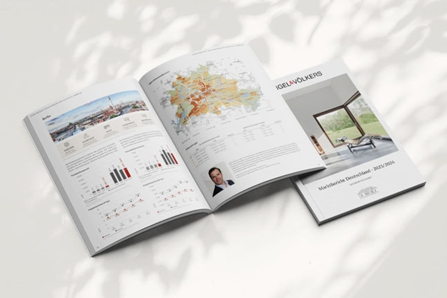Öffnen Sie den Engel & Völkers Marktbericht mit Diagrammen, Karten und einem Foto eines Mannes. Ein weiterer Bericht liegt obenauf.