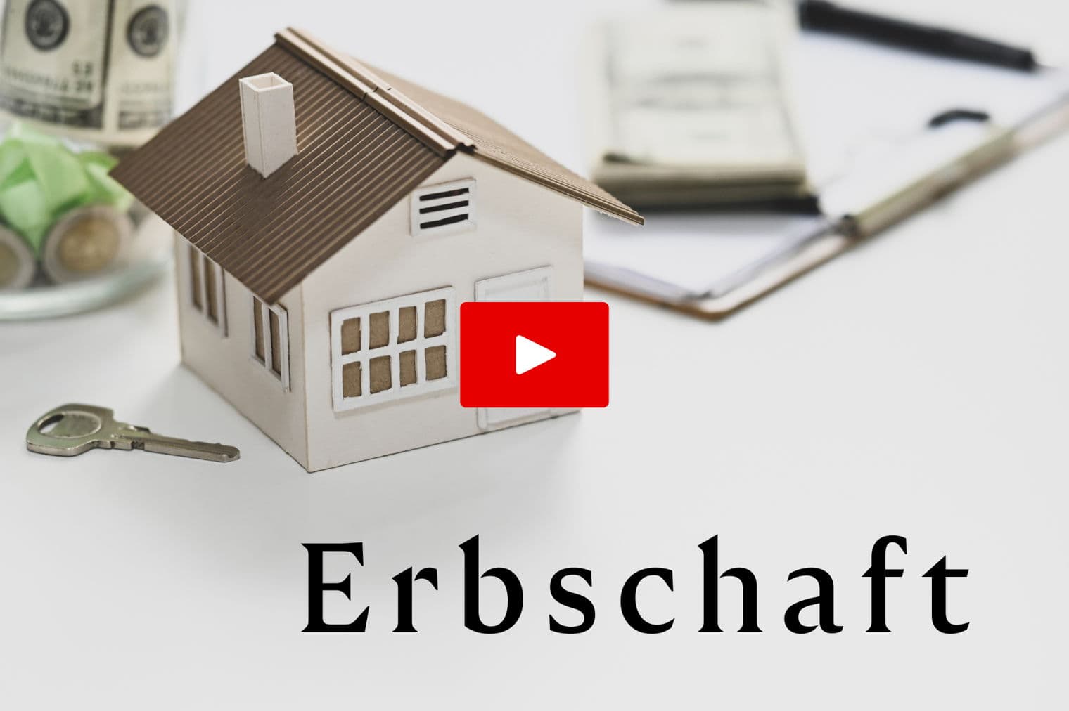 Ein Spielzeughaus, ein Schlüssel, ein Glas mit Geld und Papierkram auf einer weißen Oberfläche. Das Wort "Erbschaft" steht unter dem Haus.