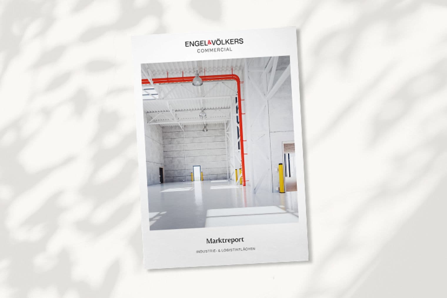 Engel & Völkers Commercial market report cover featuring a bright, empty warehouse with red pipes and white walls.
