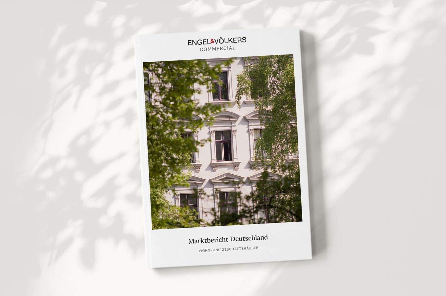 Engel & Völkers Commercial report cover featuring a white building framed by green trees.