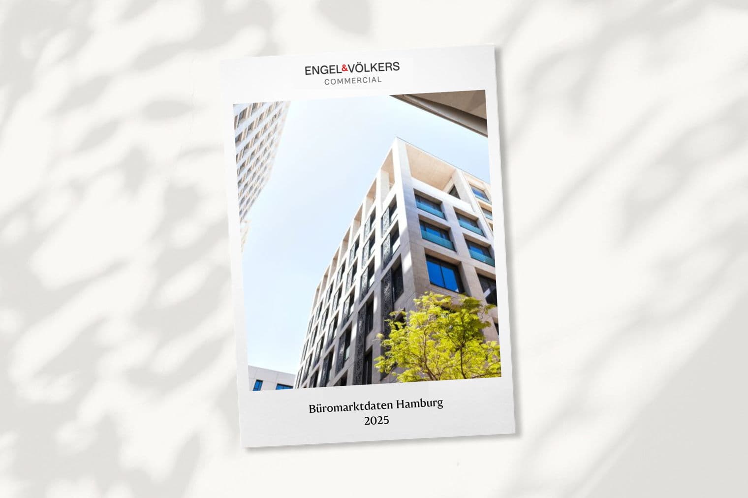 Engel & Völkers Commercial Real Estate Berichtcover. Untersicht von modernen Bürogebäuden und blauem Himmel.
