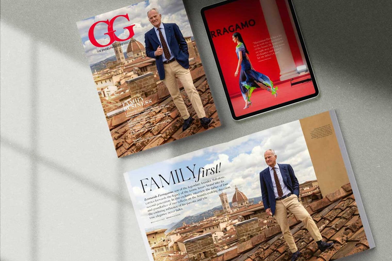 Three magazines and a tablet are displayed. One magazine features a man in a suit with Florence in the background. The tablet shows a fashion image.