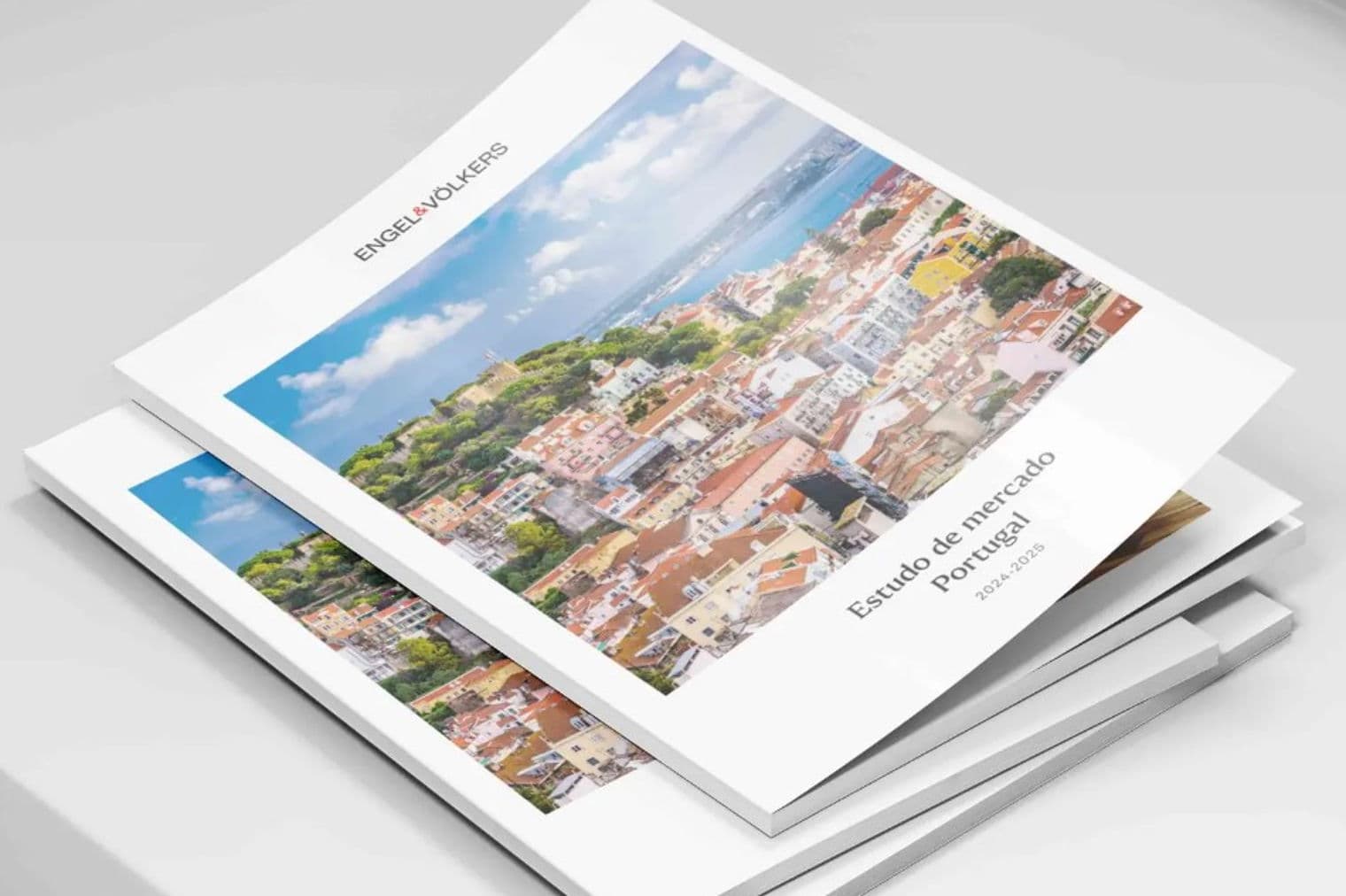 Stack of Engel & Völkers "Estudo de mercado Portugal 2024-2025" reports, cover showing a Portugal cityscape.