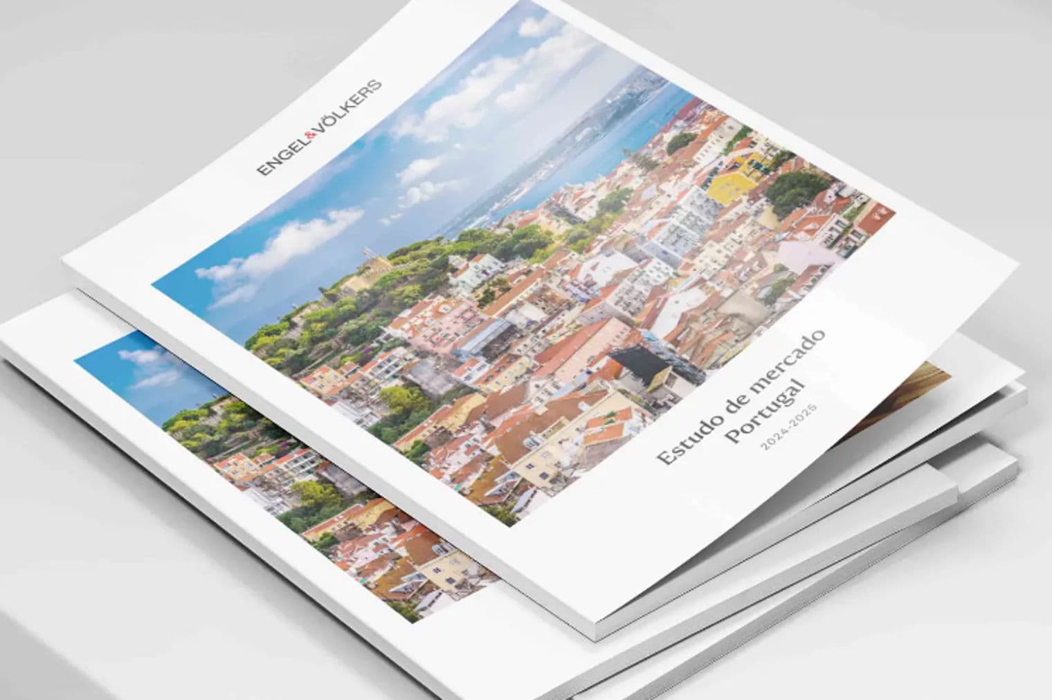 Stapel von Engel & Völkers "Estudo de mercado Portugal 2024-2026" Berichten mit einer Lissabonner Stadtansicht auf dem Umschlag.