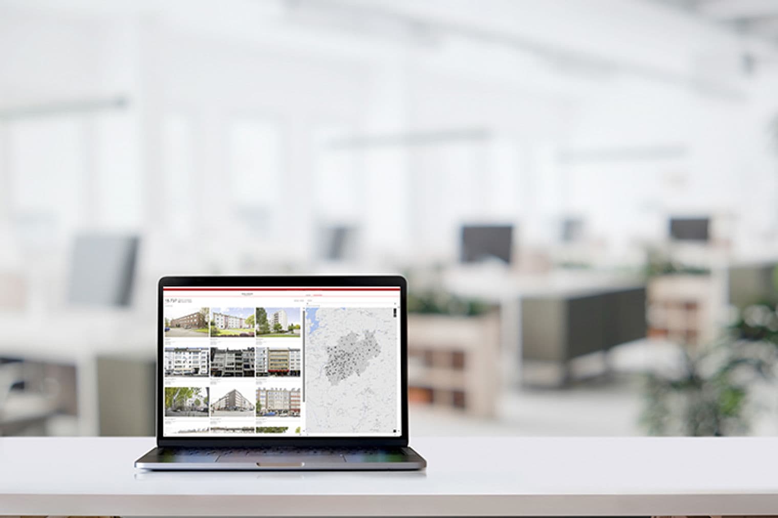 Laptop on a white desk displays real estate listings and a map in a bright office.
