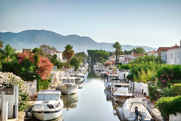 Vista de los amarres de Empuriabrava después de los puentes con embarcaciones y casas
