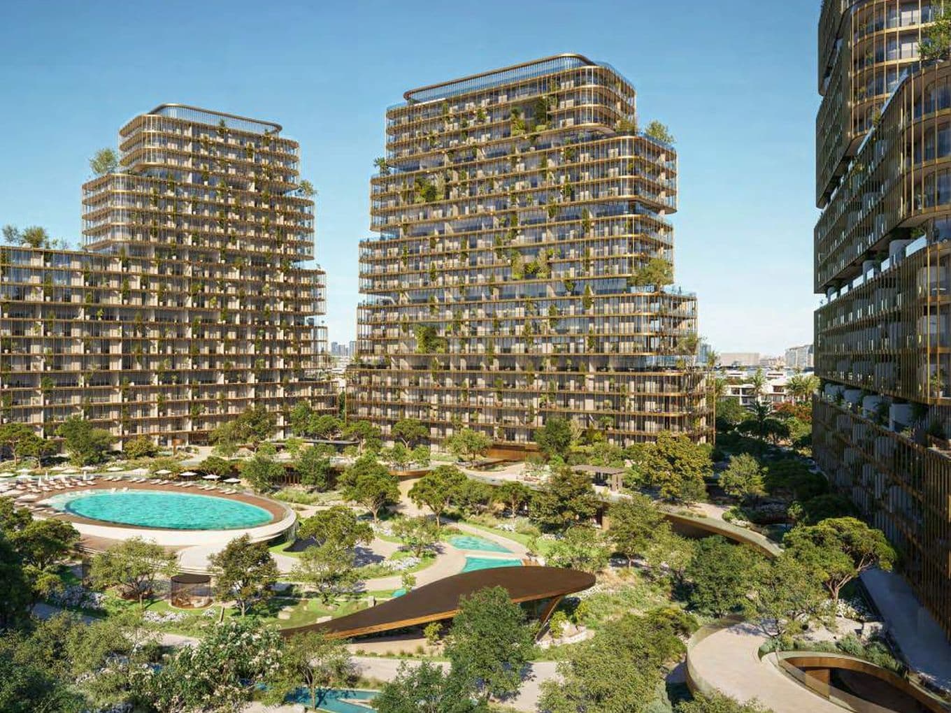 A cluster of modern, tiered high-rise buildings with rooftop greenery surrounded by lush landscaped gardens, paths, and a circular pool.