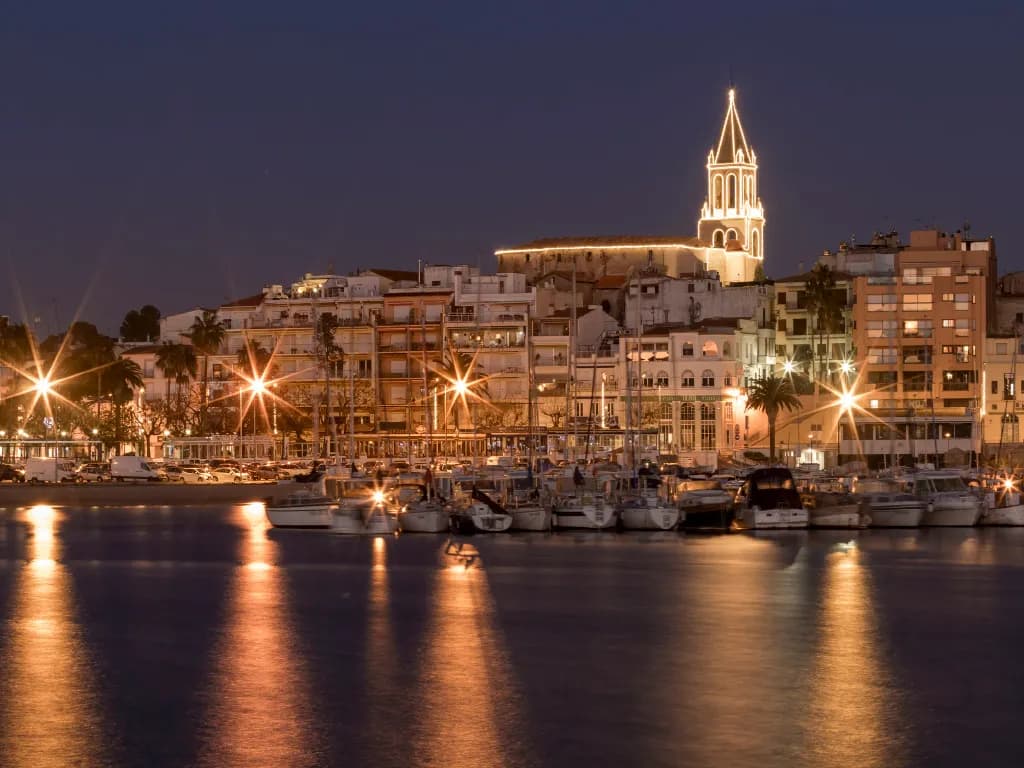 Puerto de un pueblo de la costa Brava al anochecer con el alumbrado encendido
