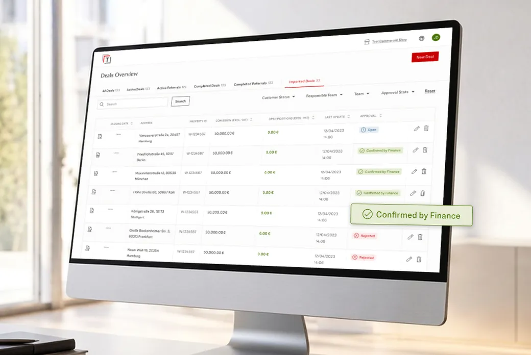 A desktop monitor shows a E&V T-Box Deals Overview table with address rows, financial figures, and a green 'Confirmed by Finance' badge. AI-generated image