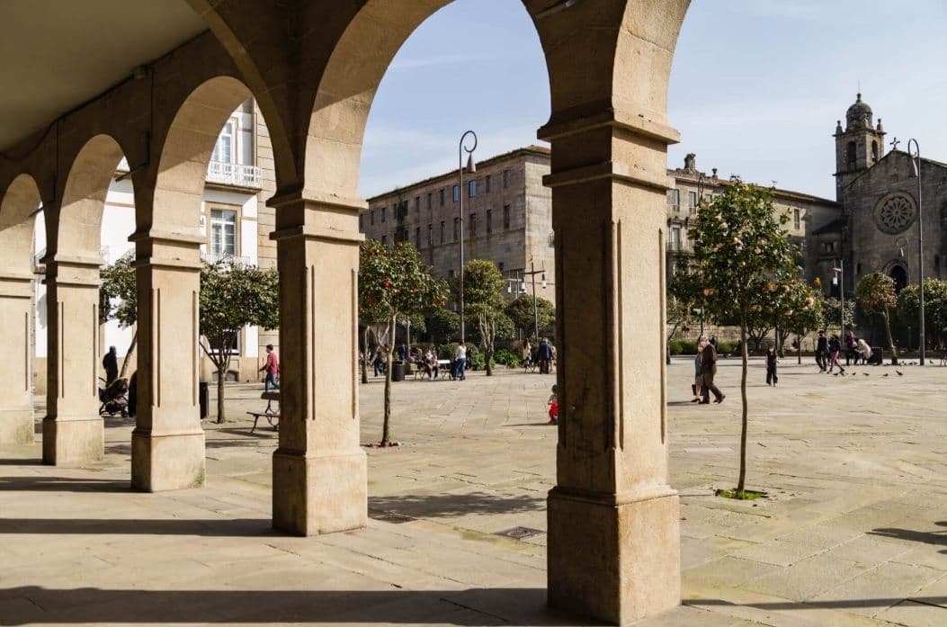 Praza da Ferrería - Pontevedra - una plaça amb una església i gent caminant.