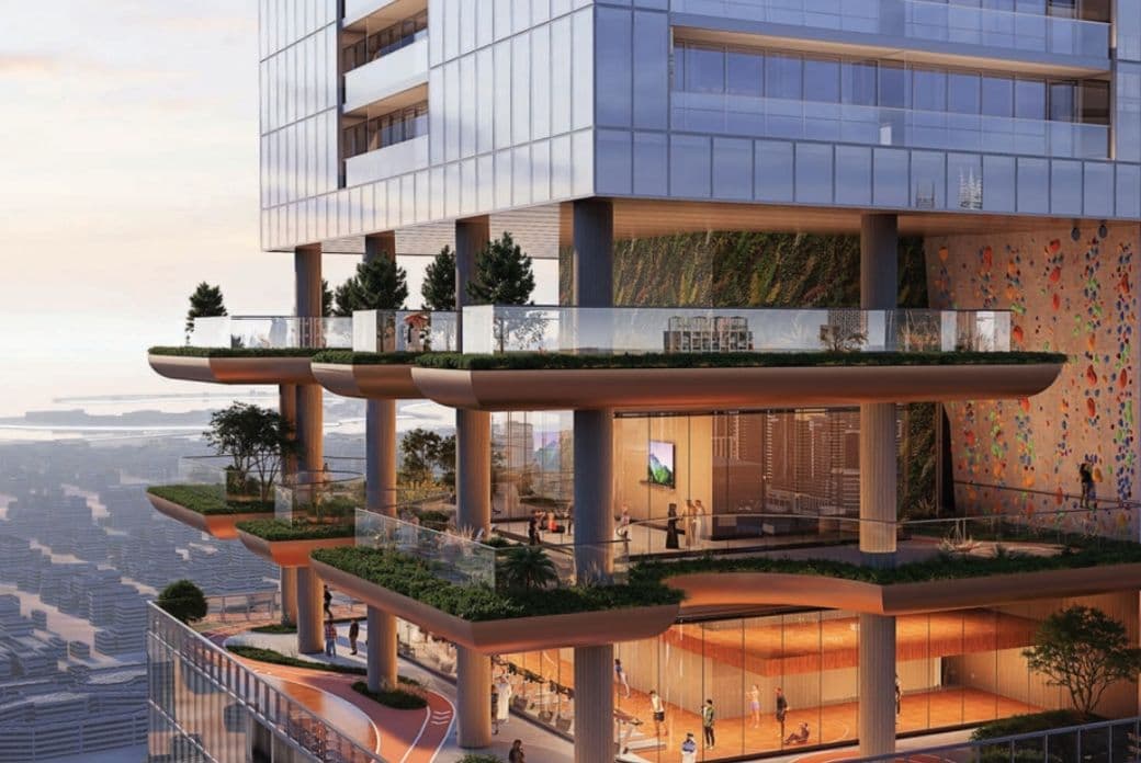 Modern high-rise building with multiple open-air terraces, greenery, and glass walls overlooking a cityscape and distant water view.