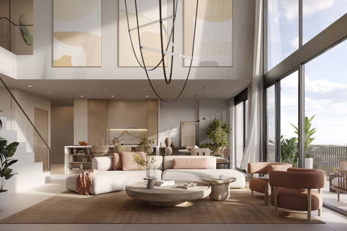 Open-plan living area in duplex at Distrikt featuring double-height ceilings and contemporary lighting.