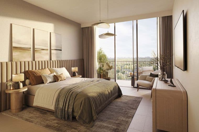 Modern bedroom in Distrikt apartment with balcony overlooking Ghaf Woods community landscape.