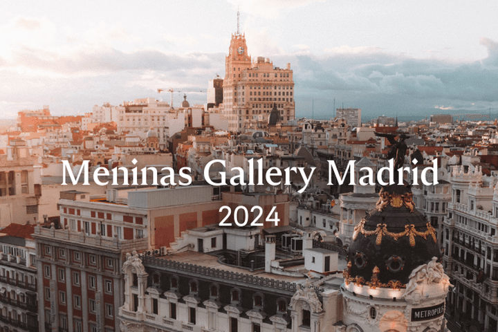 Paisatge urbà de Madrid a la posta de sol, amb edificis històrics, incloent-hi l'edifici Metrópolis amb la seva cúpula ornamentada.