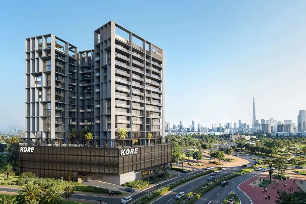Modern concrete twin-tower complex on a dark podium labeled KORE; palm trees, curved roads, and a distant city skyline.