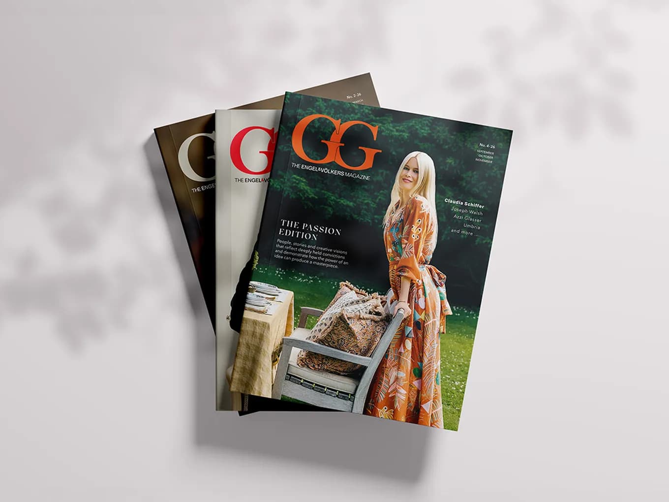 Fanned stack of GG magazines; front cover features a smiling woman in an orange floral dress outdoors beside a table and chairs.