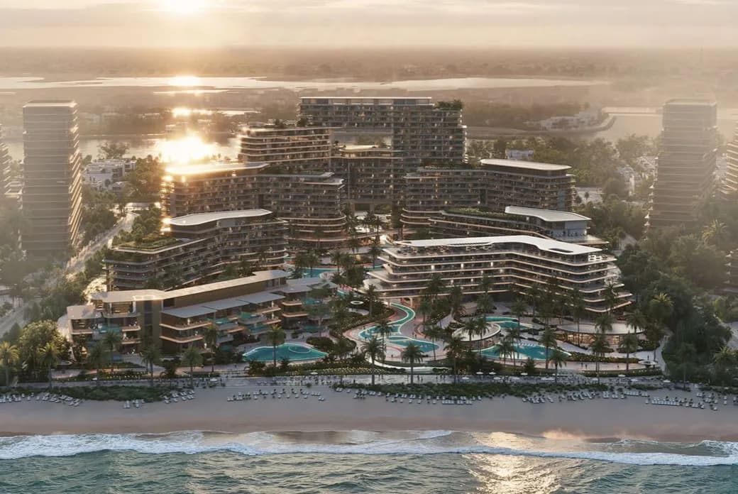 A modern beachfront resort with curved, terraced buildings, palm trees, winding pools, and a sandy beach at sunset.