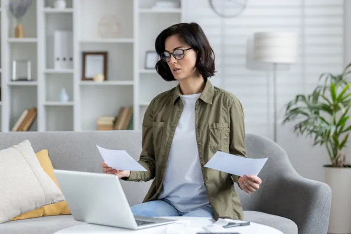 A young woman looks at bill relating to Dubai Housing Fee