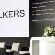 Speaker presenting at the Real Estate Forum conference with Engel & Völkers branding on stage