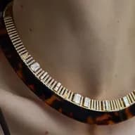 Close-up of a woman wearing a statement tortoiseshell choker necklace embellished with diamonds and gold.