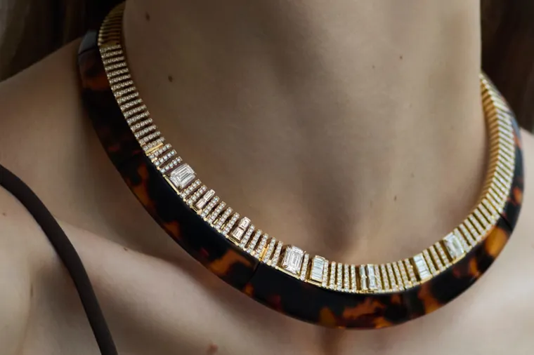 Close-up of a woman wearing a statement tortoiseshell choker necklace embellished with diamonds and gold.