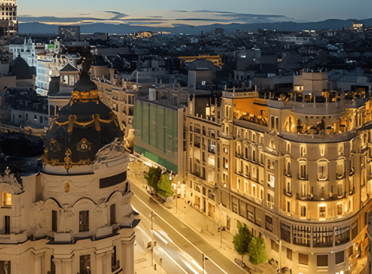 Vista aèria de Madrid de nit, amb edificis il·luminats i llums borroses provocades pel trànsit en moviment als carrers.