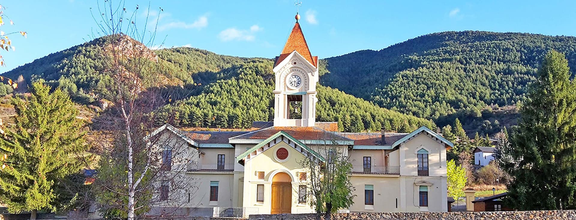 Casa Comú Das. Unique architecture of the Das Town Hall with mountains behind.