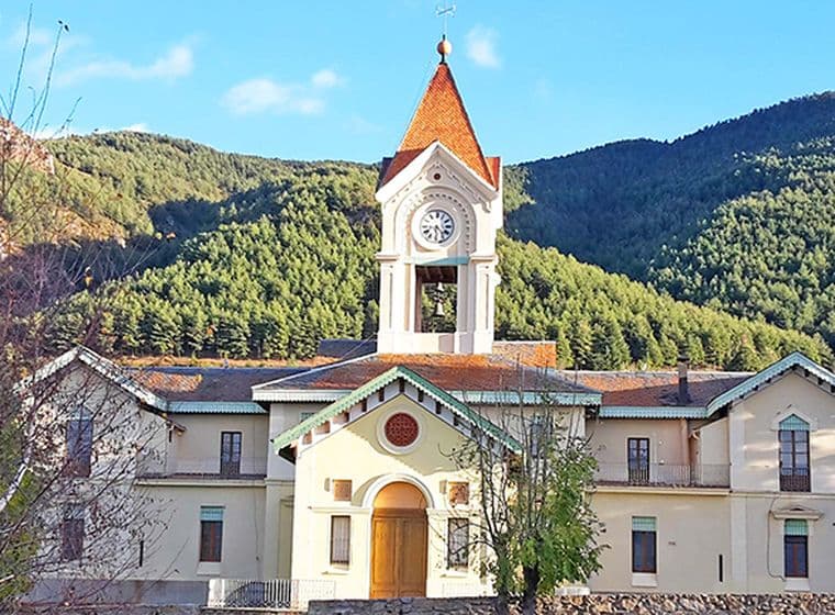 Arquitectura singular de l'ajuntament de Das amb muntanyes al darrere.