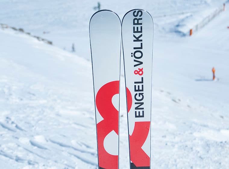 Esquís amb logo Engel&Völkers amb fons de pista d'esquí.