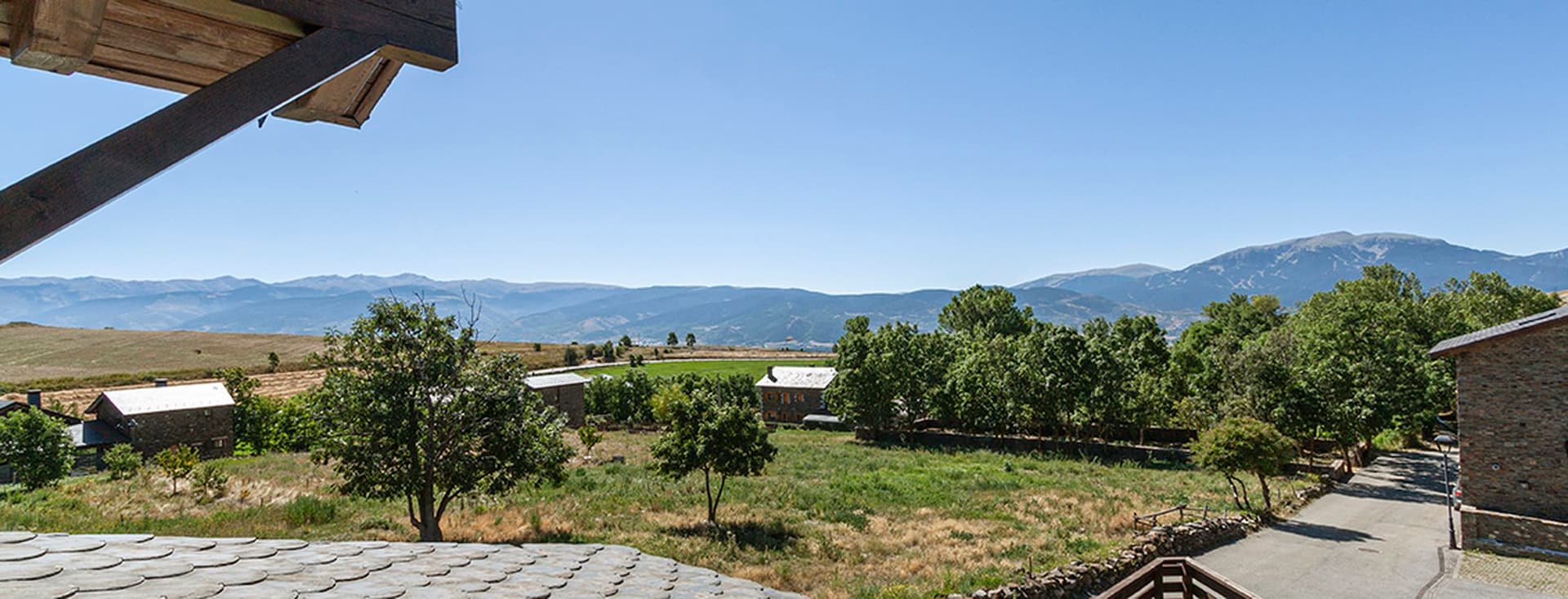 Views towards a green field and the mountains from a house in Guils.