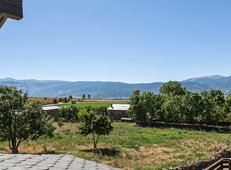 Vistes cap a un camp verd i les muntanyes des de casa a Guils.