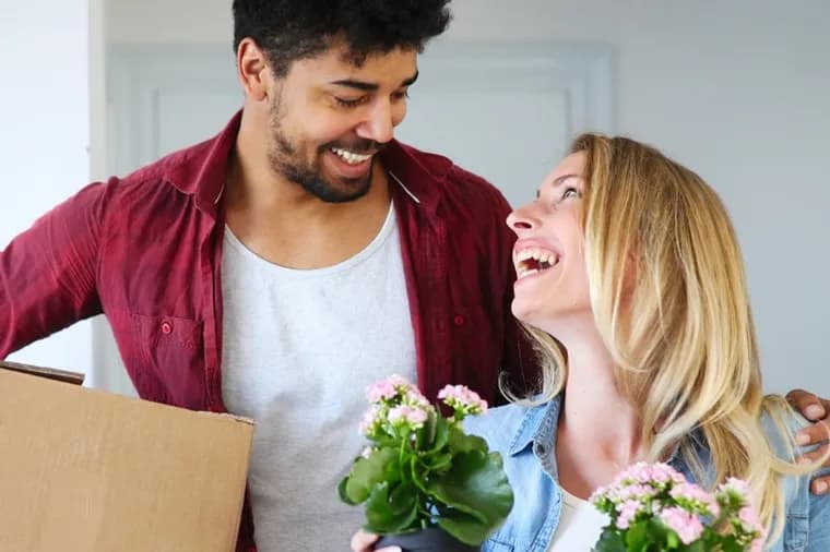 First time home buyers move boxes and plants into their new property