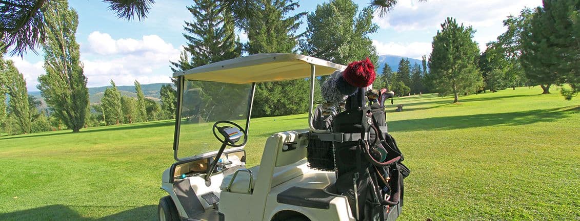 Primer pla de carro de golf en un camp de golf.