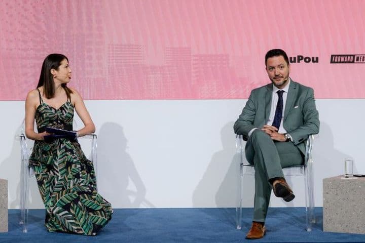 Panel discussion at White Paper The Event featuring a moderator and guest speaker on stage during a live business conversation