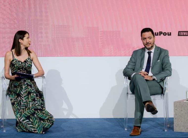 Panel discussion at White Paper The Event featuring a moderator and guest speaker on stage during a live business conversation