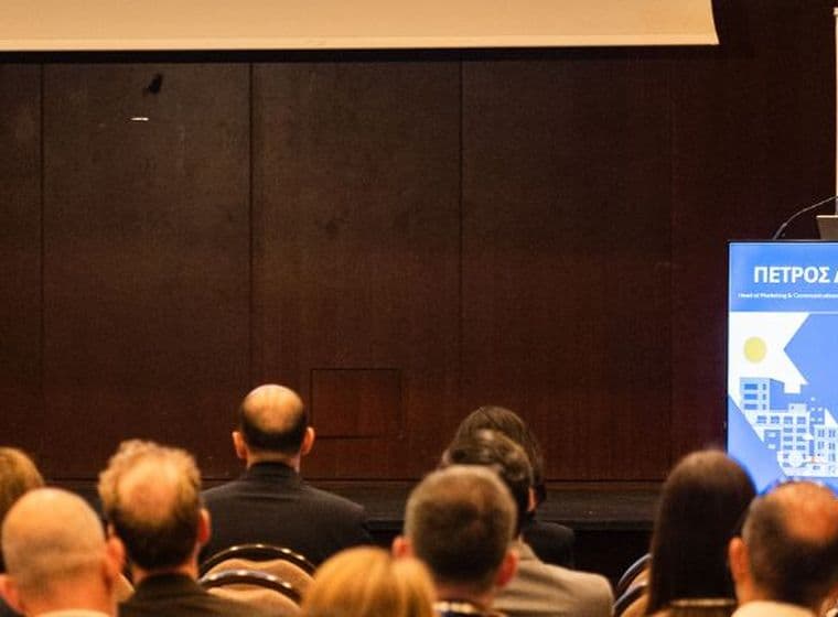 Conference speaker presenting to an audience at a real estate industry event.