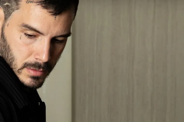 Close-up portrait of a male chef with facial tattoos thoughtfully focusing in the kitchen