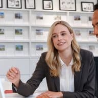 A man and a woman in business attire looking at a computer screen in an office