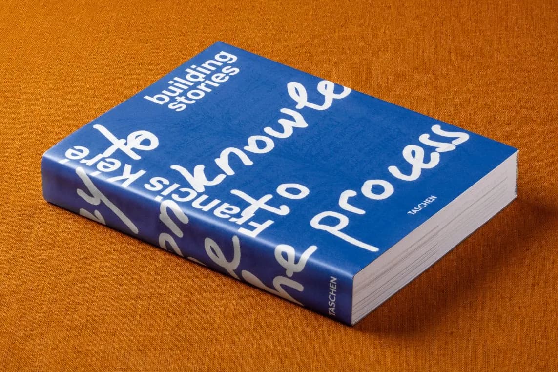 A blue hardback book with white cursive lettering on an orange fabric cover.