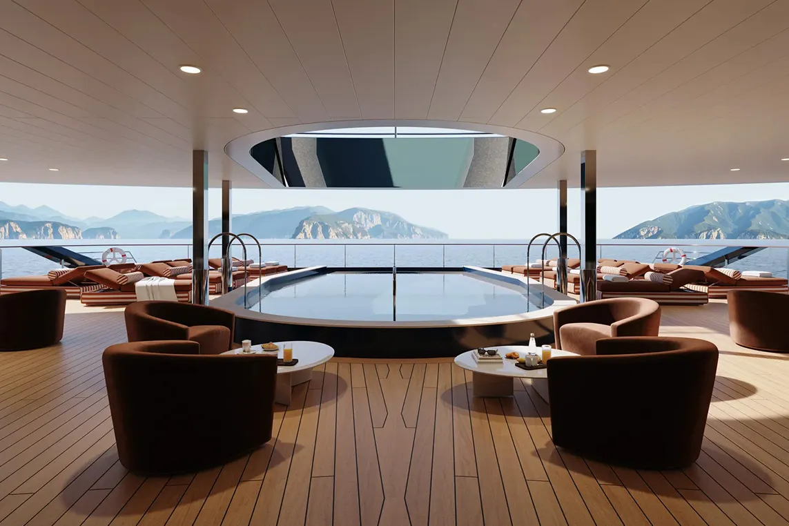 Luxurious yacht deck with a circular pool, brown lounge chairs and small tables; the ocean and distant mountains are visible.