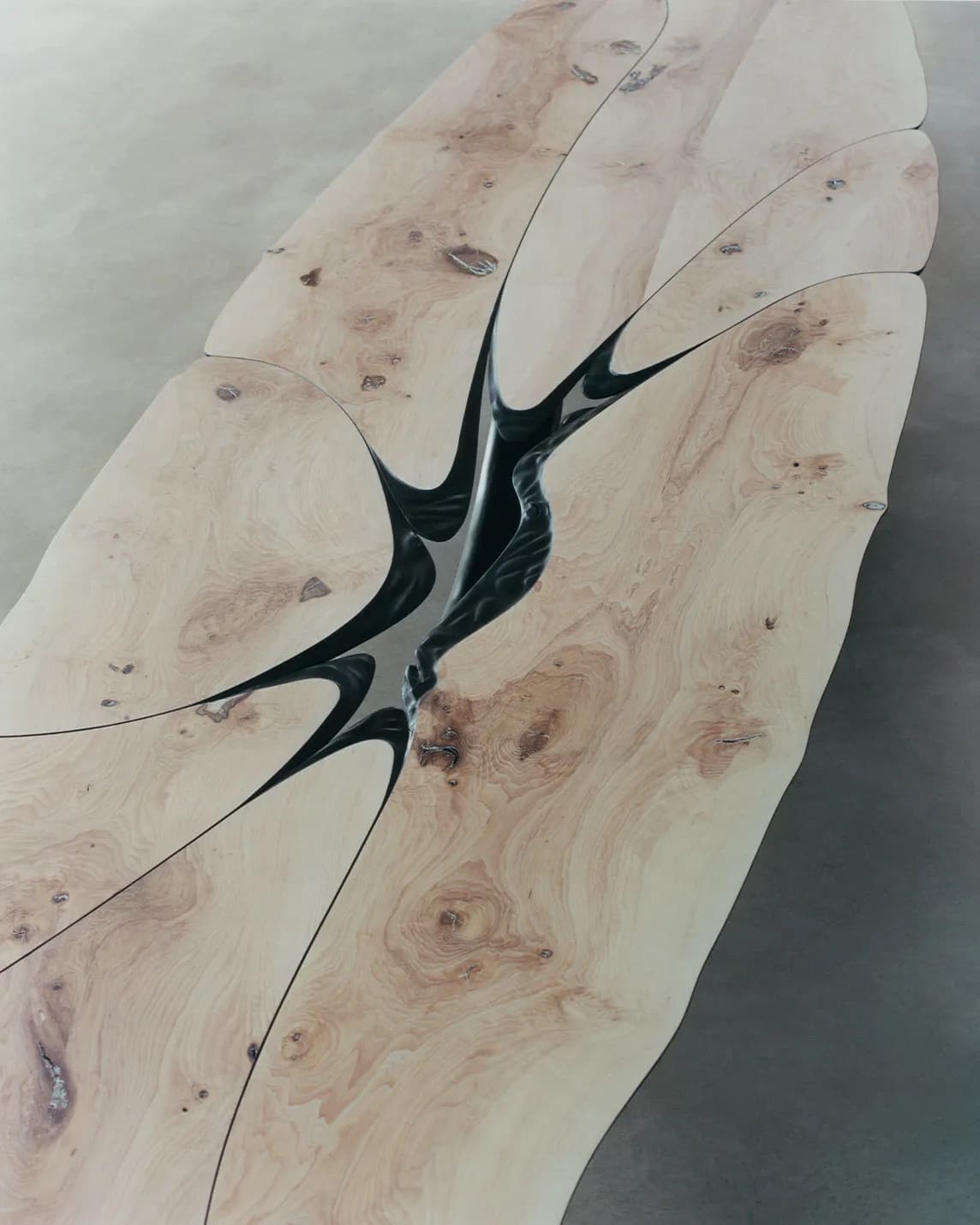 Large light wood plank split by black resin cracks forming a star-shaped pattern at the center.