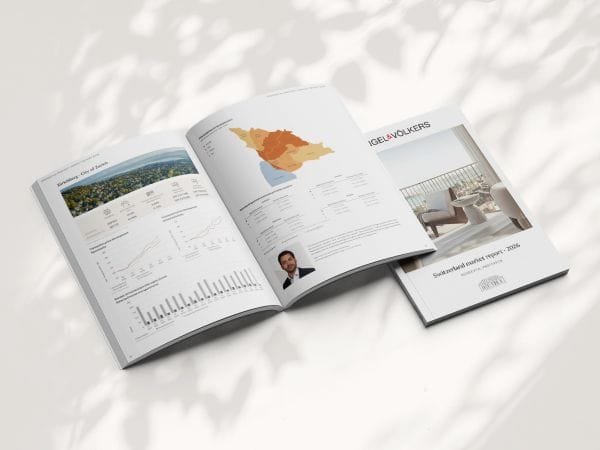 Open magazine on a light surface, featuring landscape images, a map, charts, a portrait, and a cover titled "Real Estate Market." Shadows overlay.