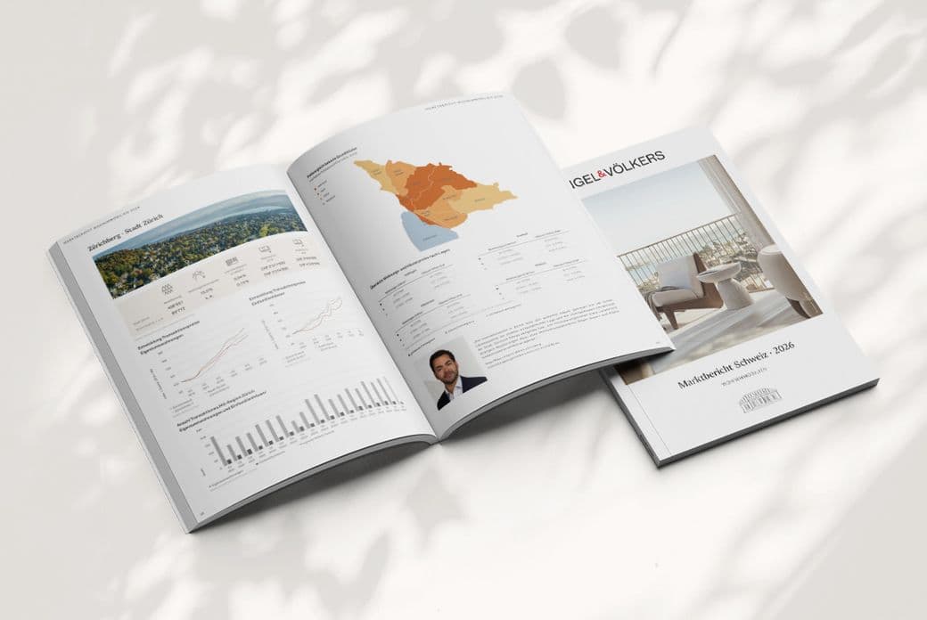 Open real estate market report showing maps, charts and a small portrait, lying beside a cover featuring a balcony photo.