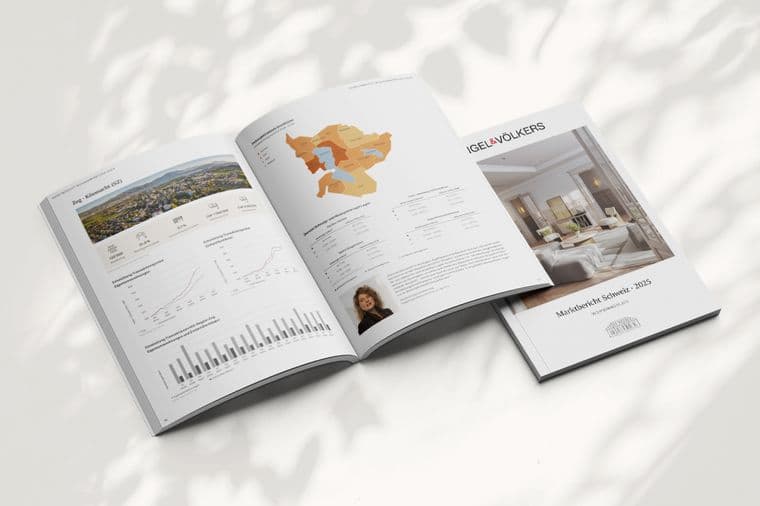 Open Engel & Völkers market report with charts, maps, and a property photo on a white surface with leaf shadows.