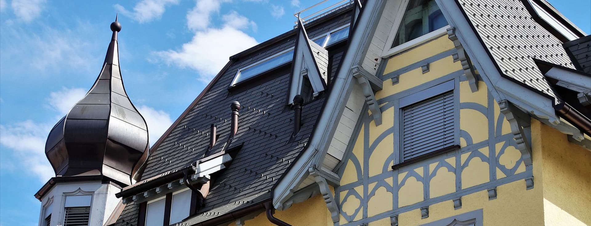 Blick von außen auf das Dachgeschoss eines gelben Mehrfamilienhauses