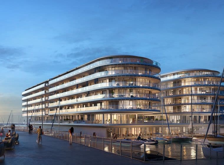 Futuristic waterfront buildings with curved glass facades at sunset, surrounded by boats and palm trees under a clear blue sky.